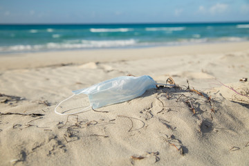 medical protective mask for coronavirus protection on the aunny beach in a tropical country at summer day