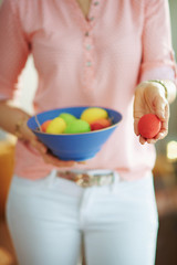 female holding blue plate with easter eggs and showing red egg