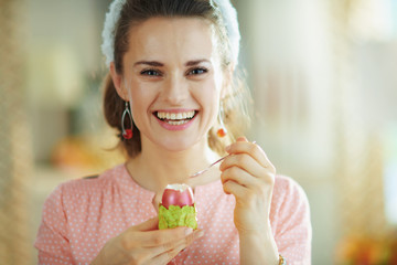 smiling modern female eating easter egg with spoon