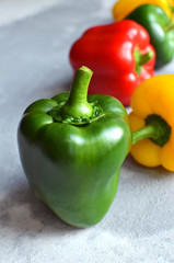Green fresh bell pepper with multi-colored sweet peppers. Green, red and yellow vegetables. Healthy food concept