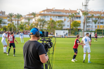 cameraman with camera shooting video on football game