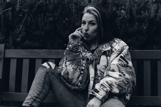 Chica chupando un caramelo sentada en un banco