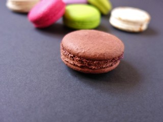 Obraz na płótnie Canvas layout of colored macaroons on a solid color background