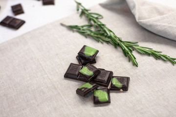bar of brown chocolate with mint slices lies on a gray background. Raw food sweets, vegans, vegetarian and sugar free, handmade chocolates