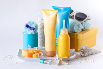 Suncare bottles, glasses, starfish on a white background. Cosmetics for the summer.