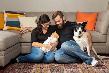 Young family with their newborn baby girl and family pet.