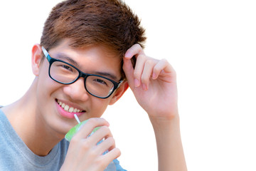 Closeup face Asian handsome teenage boy wearing glasses drinking water from straw in plastic cup, Portrait cheerful hipster young man are smiling with a happy isolated on white background in Thailand