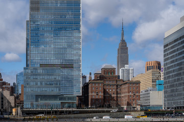 Empire state building shot from a ferry on the hudson river sticking out of the skyscrapers. New york City USA