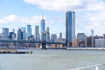 Fototapeta premium Manhattan Bridge shot from the water on a ferry with manhattan wall street behind new york city nyc USA