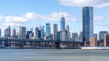Fototapeta na wymiar Manhattan Bridge shot from the water on a ferry with manhattan wall street behind new york city nyc USA