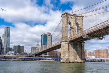 Brooklyn bridge shot from the water on a ferry with manhattan wall street behind new york city nyc...