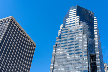 Obraz premium Odbicia chmur na szklanym wieżowcu w Nowym Jorku, malowniczy widok od dołu