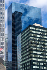 Fototapeta na wymiar Reflections of the clouds on a glass skyscraper in new york city, scenic view from below