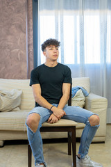 Young man posing on a living room sofa
