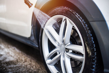 Car wheel wash. Car cleaning with water jet. Car rim or aloy washing close up. © Milan