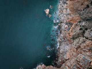 Top-down view at rocky shore with turqoise water