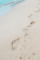 Holiday symbol of quiet rest in attractive areas on the beach, with visible footprints in the sand. Concept for travel vacation - footsteps in sand on summer tropical getaway holidays vacation