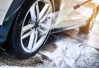 Car wheel wash. Car cleaning with water jet. Car rim or aloy washing close up.