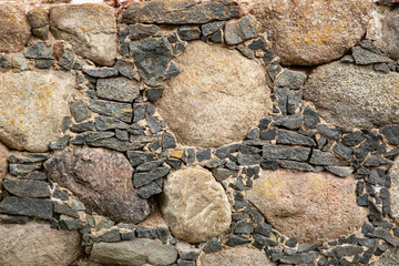 old masonry of small and large stones covered with lichen