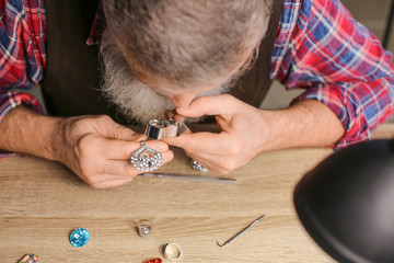 Obraz premium Jeweller examining adornment in workshop