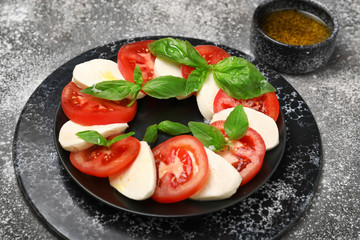 Fototapeta na wymiar Mozzarella cheese with tomatoes and basil on plate