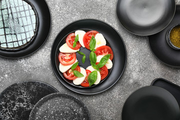Mozzarella cheese with tomatoes and basil on grey background