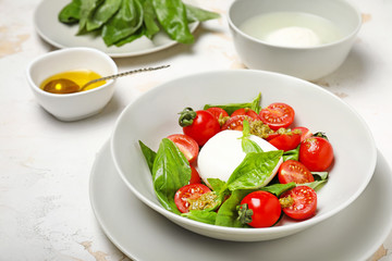 Mozzarella cheese with tomatoes, basil and pesto sauce on plate