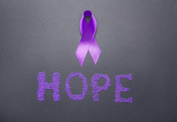Violet ribbon and word HOPE on dark background. Domestic violence concept