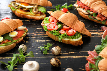 Tasty croissant sandwiches on table