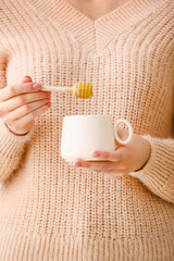 Woman drinking tea with honey, closeup