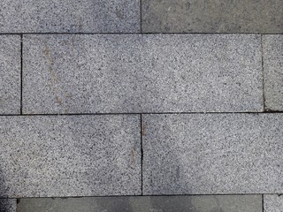 grey granite tiles are laid on the streets of the city