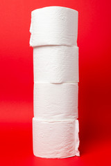 Symbol image for corona crisis panic buying / hoarding. Pile of toilet paper on red Background, with copy space.