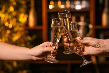 Women clinking glasses of tasty champagne in bar