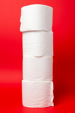 Symbol image for corona crisis panic buying / hoarding. Pile of toilet paper on red Background, with copy space.