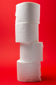 Symbol image for corona crisis panic buying / hoarding. Pile of toilet paper on red Background, with copy space.