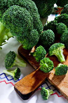 Broccoli florets on wooden cutting board in day light