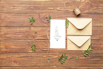 Composition with greeting card for mother on wooden background