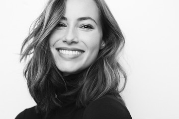 Black and white portrait of young happy woman with a big smile on her face