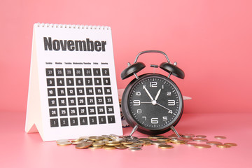 Alarm clock, calendar and coins on color background. Time management concept