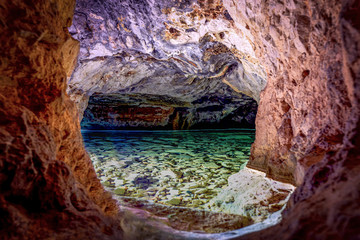 A cave with colorful walls and a tank full of water.