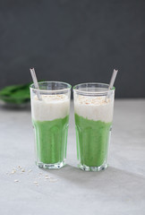 Vegan drink spinach smoothie with oatmeal smoothie in a glass on a light background