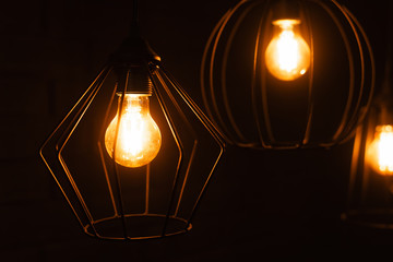 Close-up of an incandescent lamp. Light bulb with orange light. Burning an incandescent edison lamp...