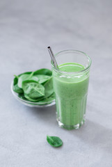 Green drink spinach smoothie in a glass on a light background