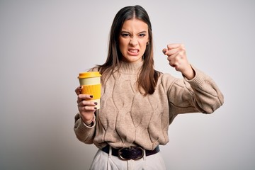 Young beautiful brunette woman drinking glass of coffee over isolated white background annoyed and frustrated shouting with anger, crazy and yelling with raised hand, anger concept