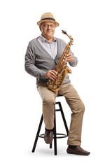 Naklejka premium Elderly man sitting on a chair and holding a saxophone
