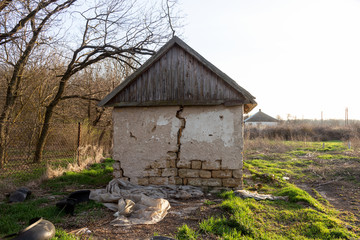 Old abandoned building with ruined windows and walls. Huge large cracks in old brick wall. Abandoned house not needed. Devastation after earthquake. Apocalypse