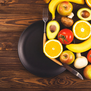 Intermittent Fasting Concept. Black Plate On A Wooden Table With Food, Located At The Time Of The Period Of Nutrition And Fasting. Top View, Flat Lay.