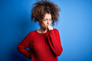 Fototapeta na wymiar Young beautiful woman with curly hair and piercing wearing casual red sweater feeling unwell and coughing as symptom for cold or bronchitis. Health care concept.
