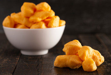 Bowl of Cheddar Cheese Curds on a Rustic Wooden Table