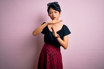 Young beautiful asian girl wearing casual dress standing over isolated pink background Doing time...